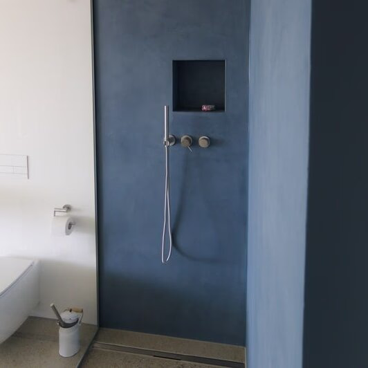 Blaue Dusche in einem fugenlosen Bad