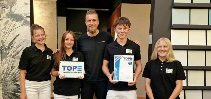 Auszubildende und Marco Thommen mit der Auszeichnung "Top Ausbildungsbetrieb"