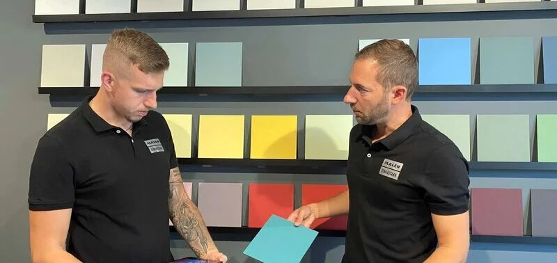 Zwei Männer bei der Auswahl von Farbtafeln