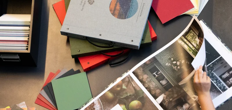 Farbpaletten und Bücher mit Tapetenmustern auf einem Tisch