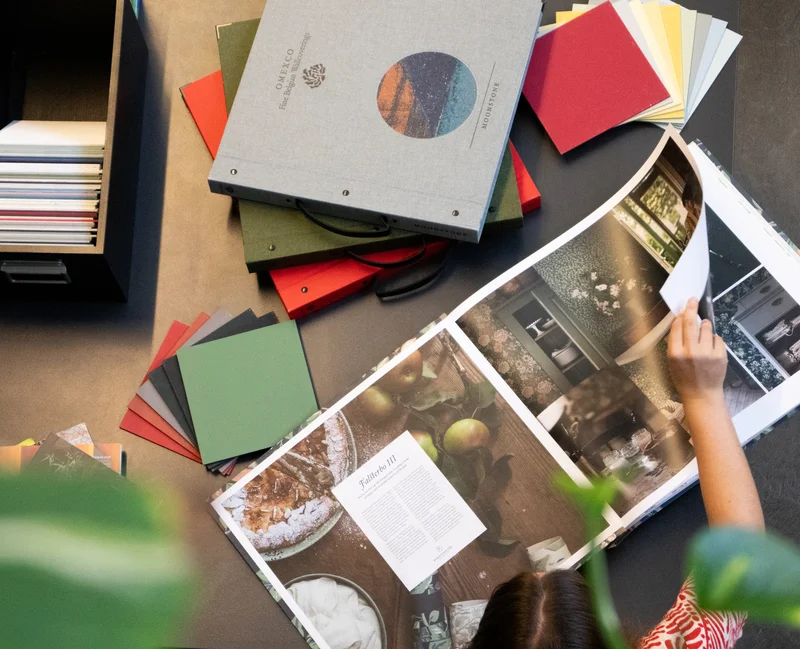 Farbpaletten und Bücher mit Tapetenmustern auf einem Tisch